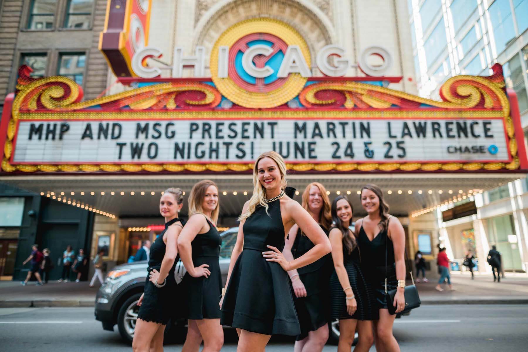 Six female friends on a bachelorette trip together in front of the Chicago theatre in Chicago, USA