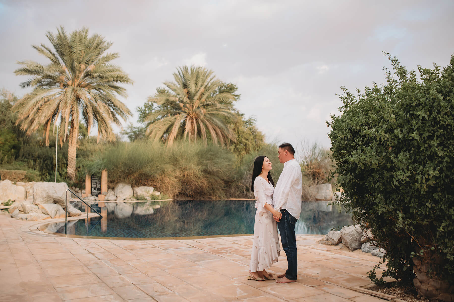 Asian couple hugging each other and laughing on a couples trip to Dubai, United Arab Emirates