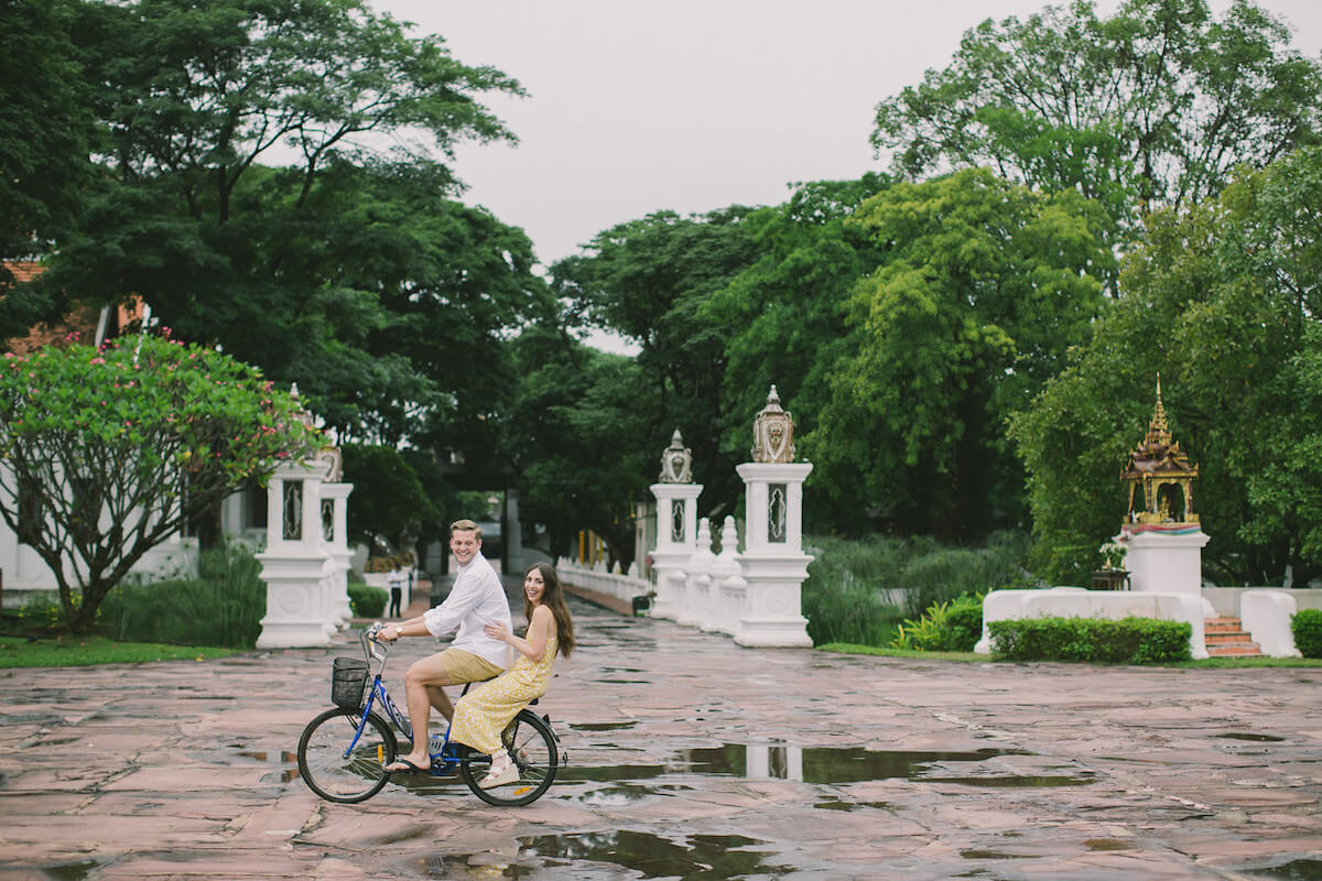 Couple riding a bicycle in Chiang Mai, Thailand on a photo shoot with Flytographer