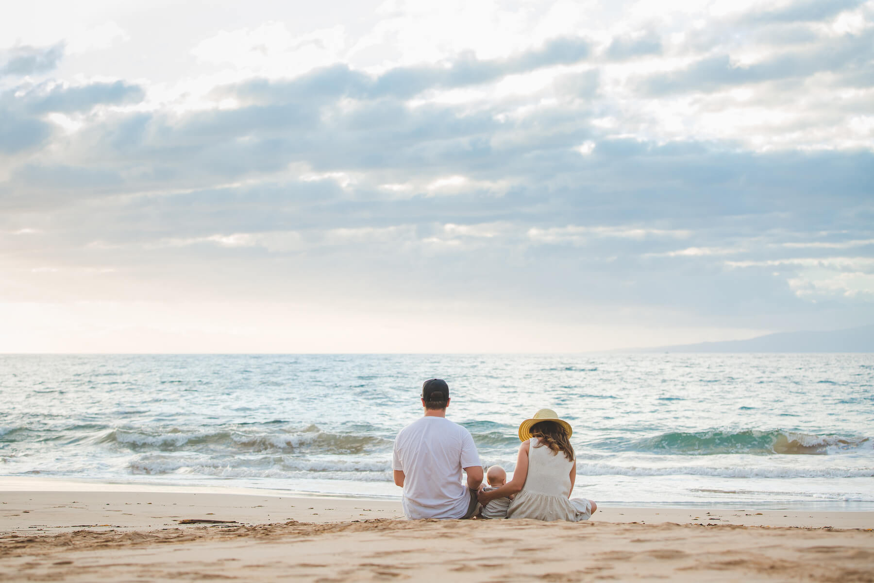 family sitting on the beach in Maui, Hawaii