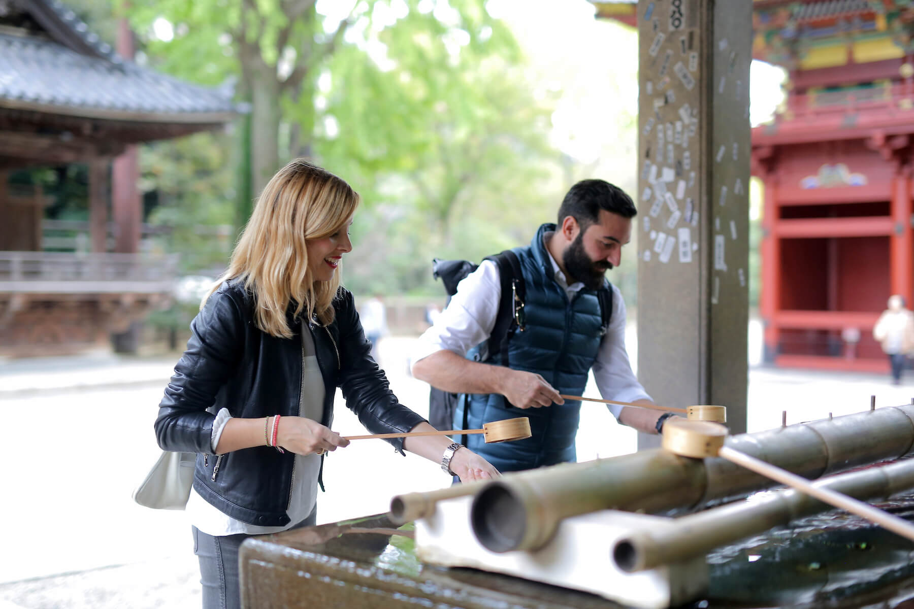 Couple outside a temple pouring water in Tokyo, Japan