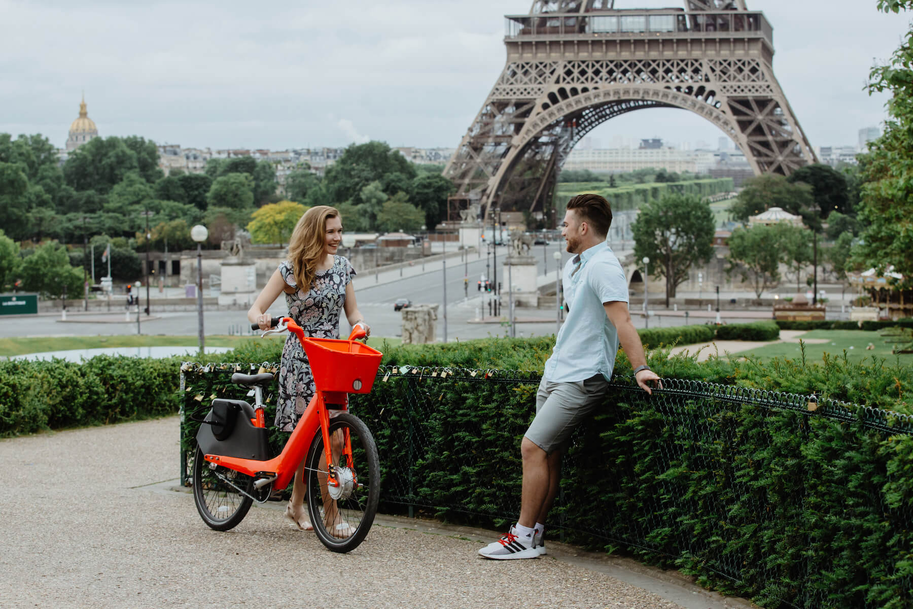 woman with a red bike talking to her finance before the big proposal, in front of the Eiffel Tower, Paris, France