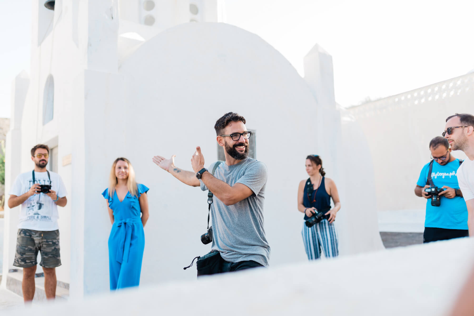 Photographer talking to group in front of church in Santorini, Greece