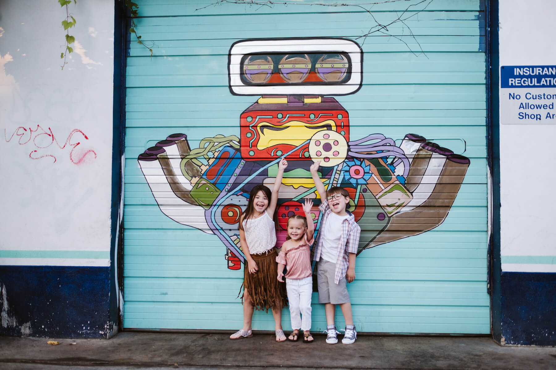 Kids in front of graffiti having fun and holding that arms up in the air in Austin, Texas