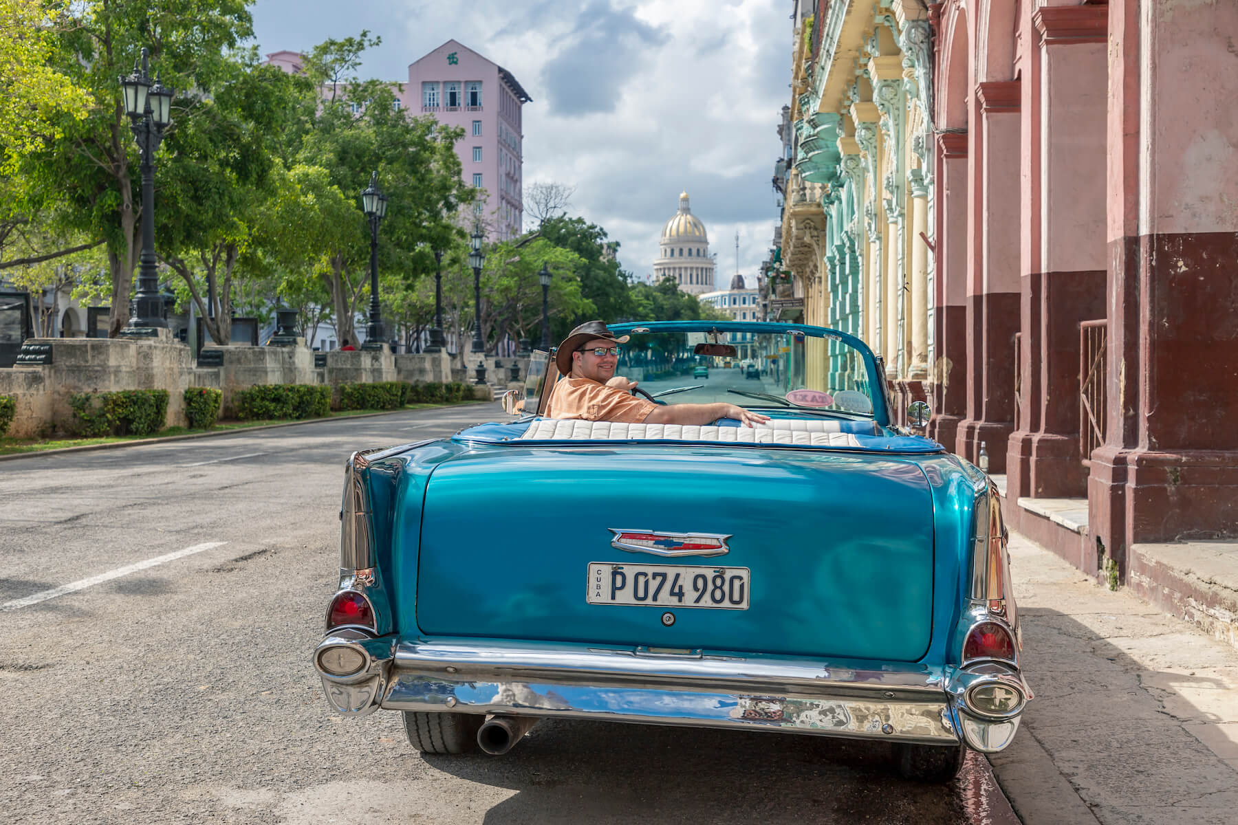 solo traveller sitting in a vintage car in Havana, Cuba