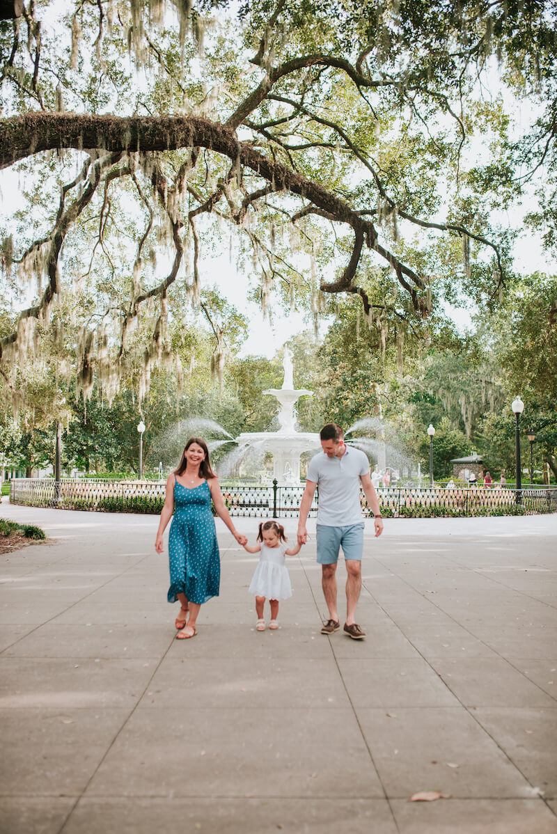 a family of three walking in a park in Savannah, Georgia, United States of America