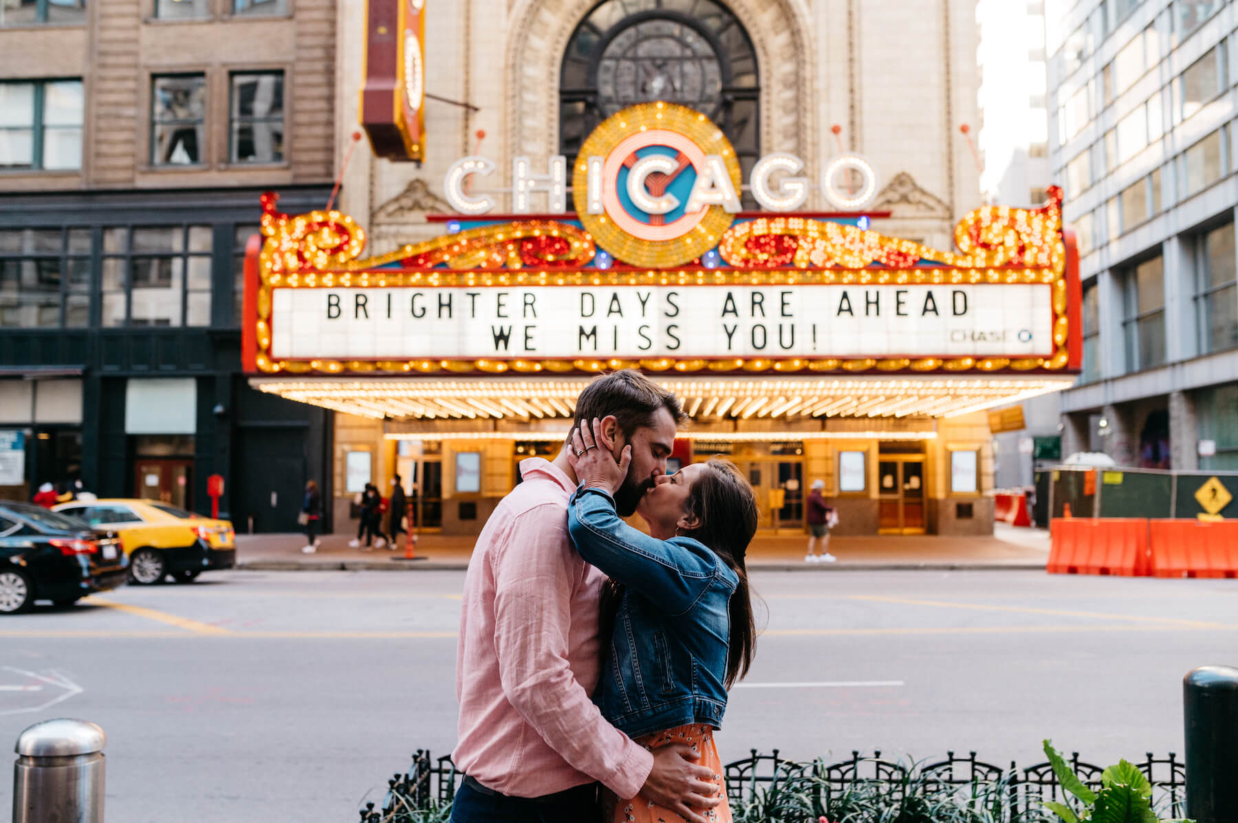 A couple kissing in front of the Chicago Theatre in Chicago on a couple photoshoot with Flytographer.