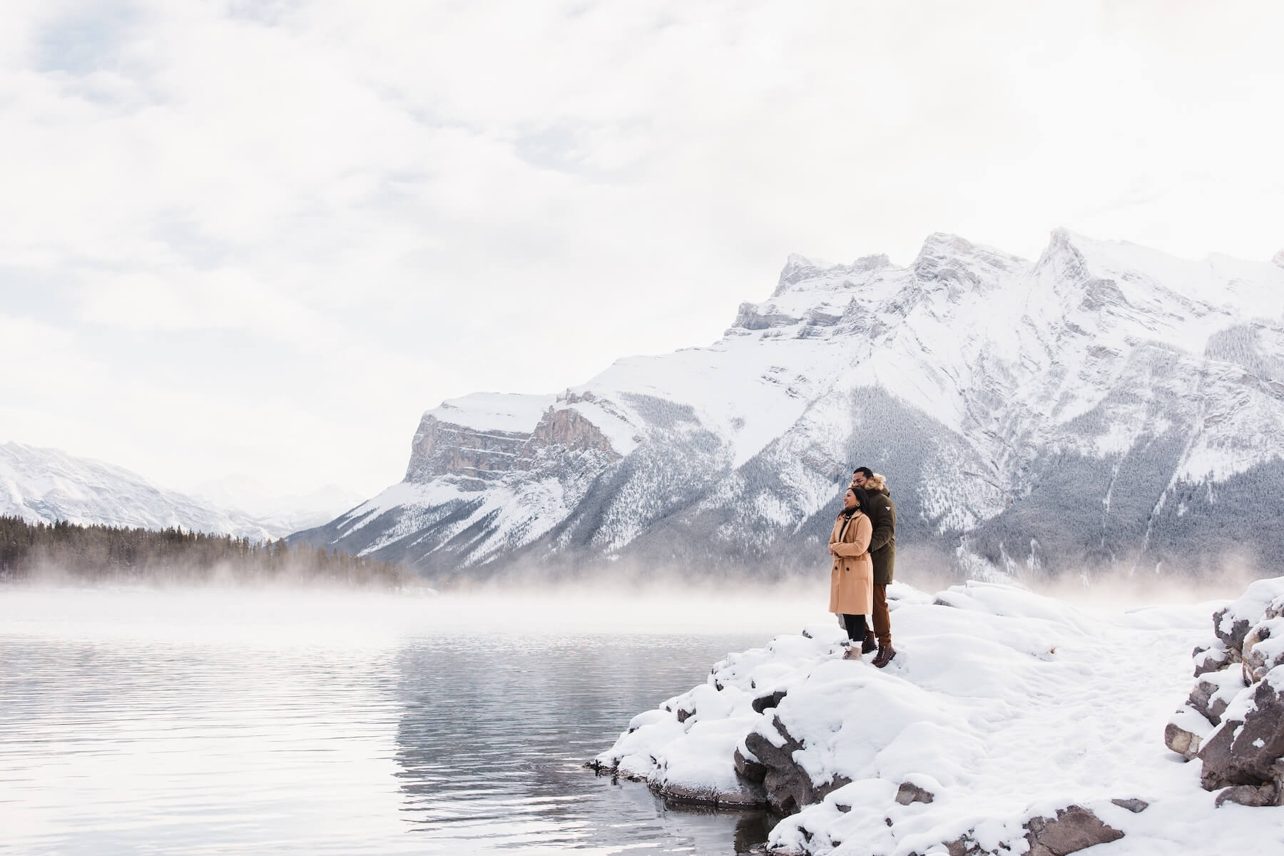 A hugging at Lake Minnewanka on a Flytographer shoot in Banff, Canada
